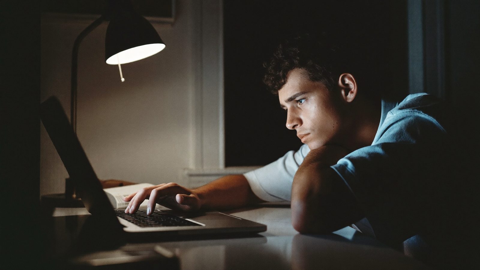 Aluno fechando o notebook, cansado, prestes a desistir